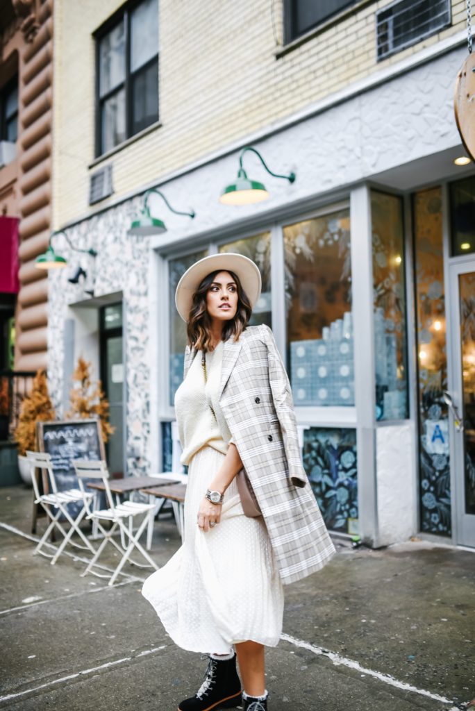 Lulus NYFW outfit with midi skirt, cream sweater and plaid jacket