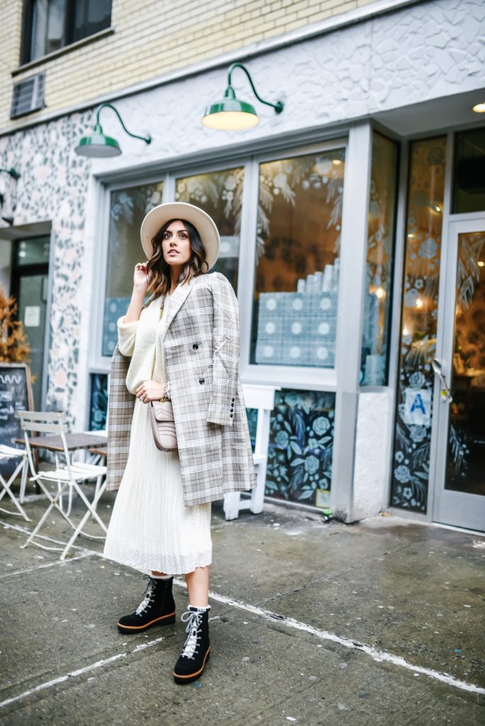 Lulus NYFW outfit with midi skirt, cream sweater and plaid jacket